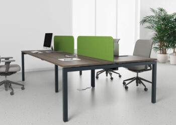 Mesa colectiva con varios puestos de trabajo separados por pantallas 