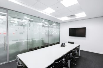 Sala de reuniones dentro de una oficina minimalista con una mesa blanca, un color recomendado para mejor ergonomía