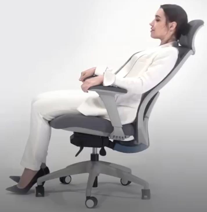 Oficinista reclinando el respaldo alto de su silla de oficina con reposacabezas