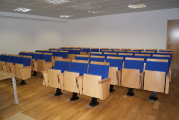 Aula universitaria equipada con bancadas colectivas tapizadas que combinan comodidad y funcionalidad