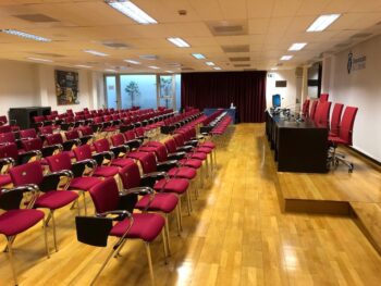 Sala de conferencias para clases numerosas equipada con sillas con pala
