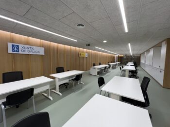 Puestos operativos con sillería ergonómica negra y mesas blancas en la Xunta de Galicia.