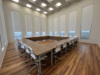 Sala de reuniones con mesa moderna con hueco central para facilitar la conectividad de los equipos.